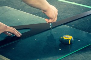 The glazier cuts the glass on a professional table